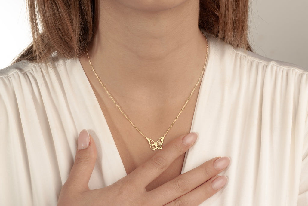 Minimalist butterfly pendant necklace worn by a woman