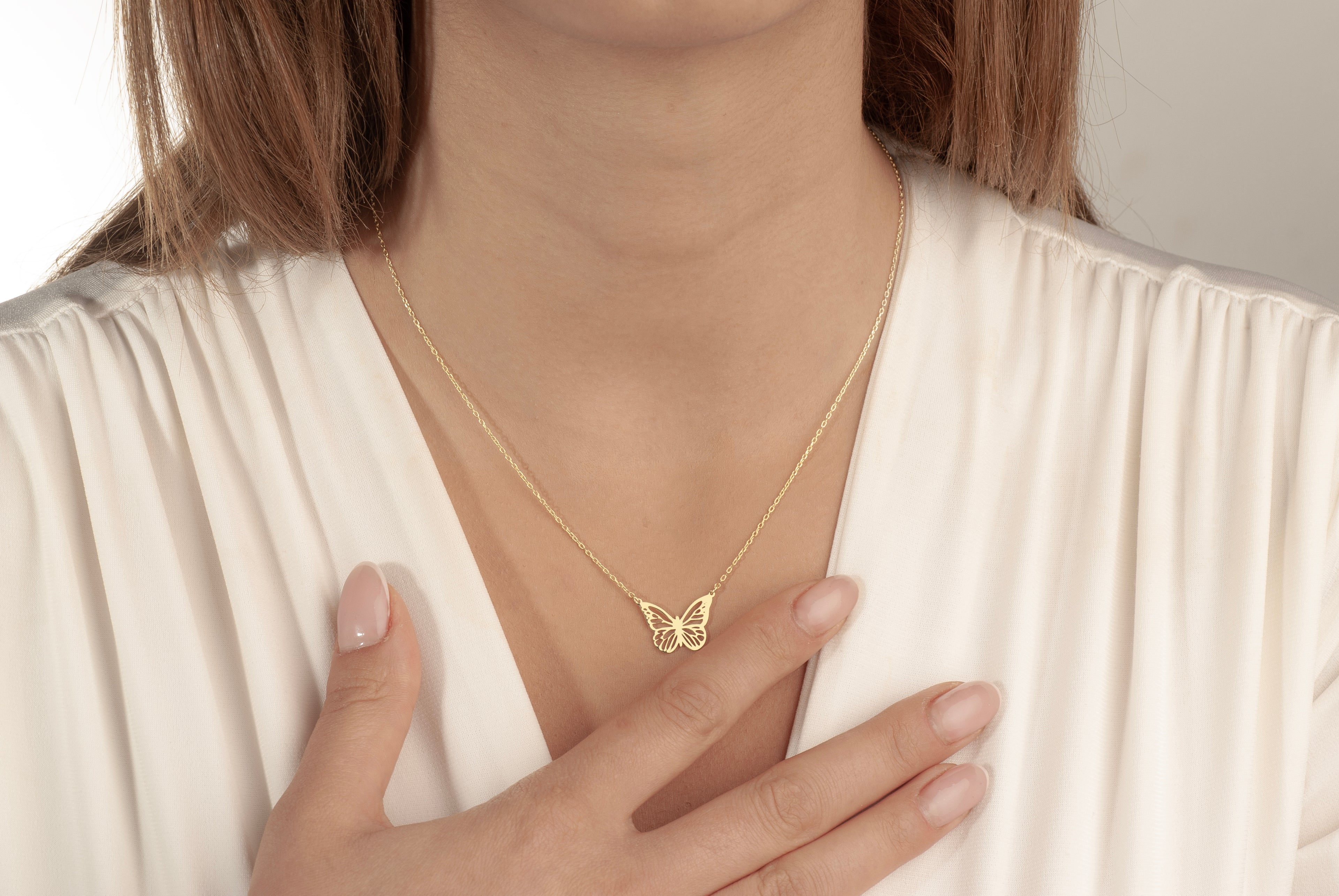Minimalist butterfly pendant necklace worn by a woman
