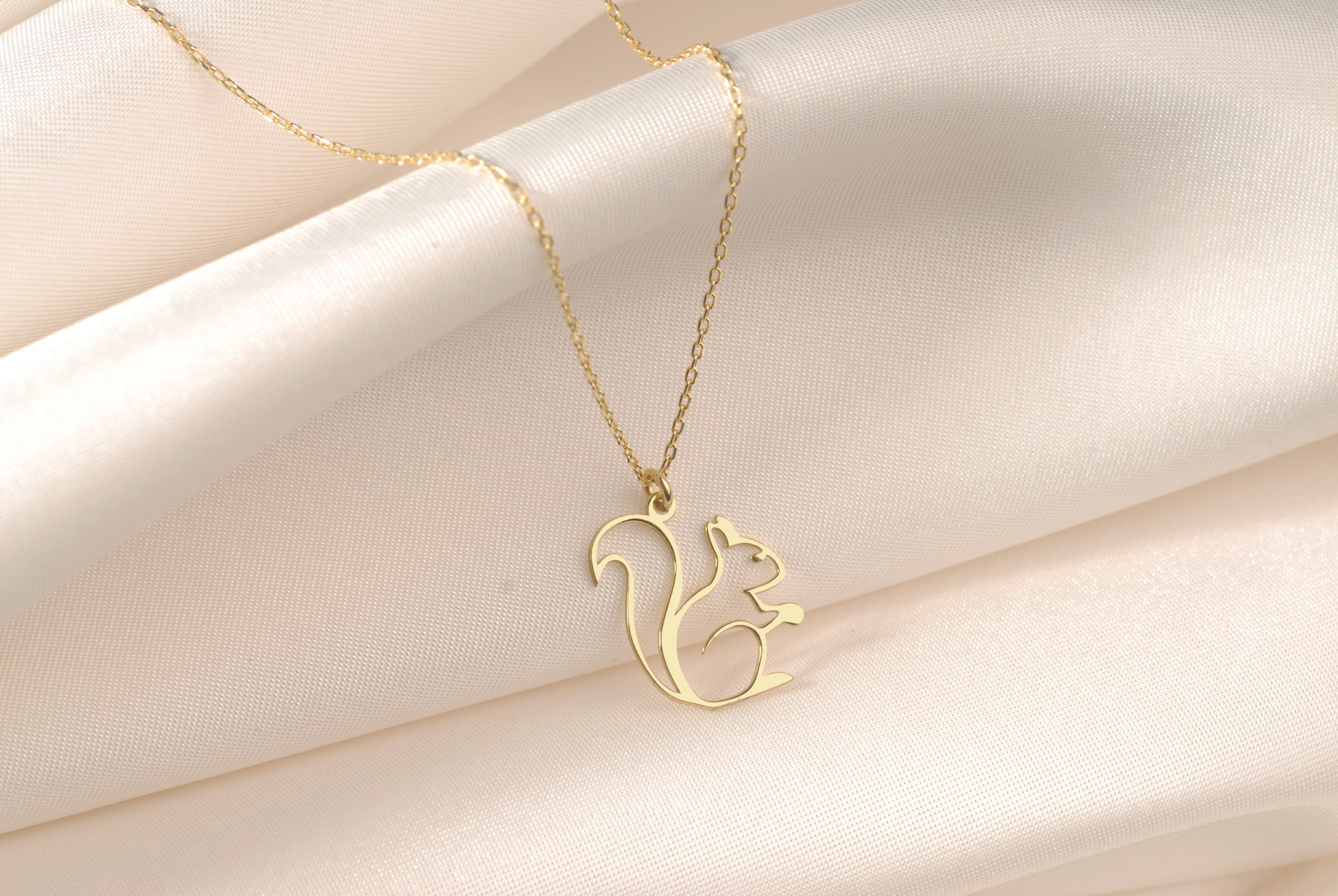 Close-up of an openwork gold squirrel pendant