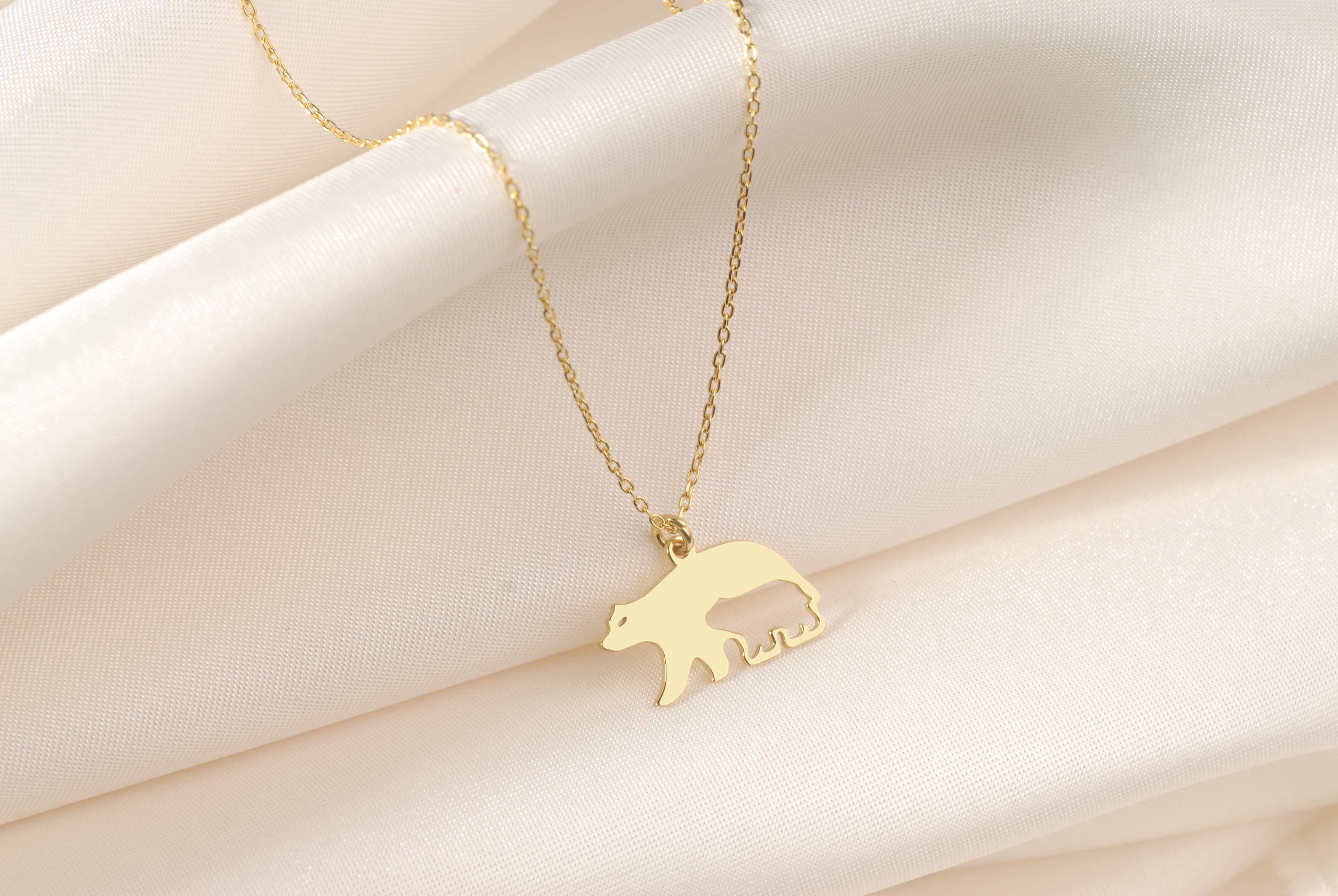 Close-up of a Mama Bear pendant with baby bear silhouette